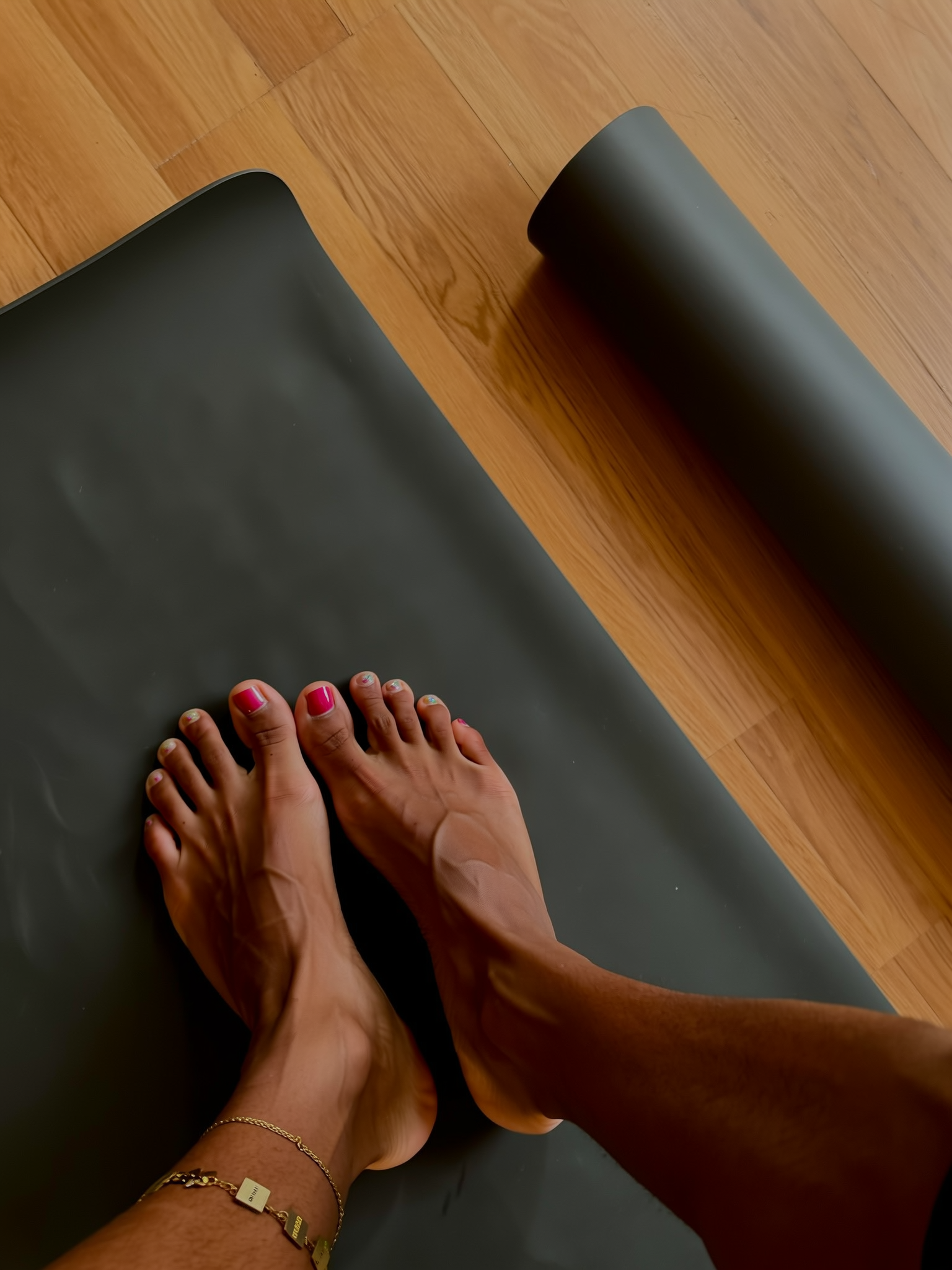 Blote voeten op een yogamat, net uitgerold op de houten vloer